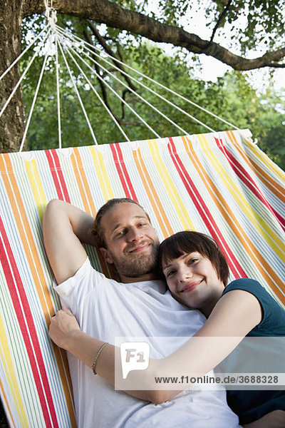 A young happy couple lying in a hammock together