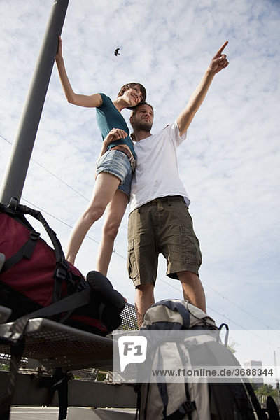 A young couple having fun while waiting on a train platform