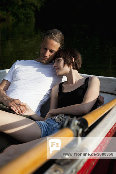 Ein junges  liebevolles Paar  das in einem Ruderboot liegt.