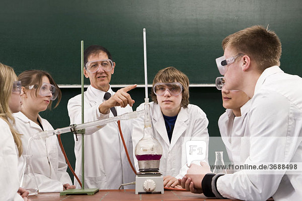 Ein Lehrer  der seinen Schülern ein Chemie-Experiment zeigt.