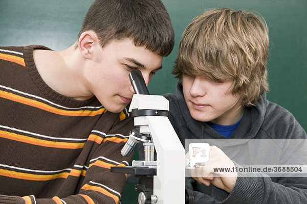 Zwei Studenten arbeiten zusammen mit einem Mikroskop