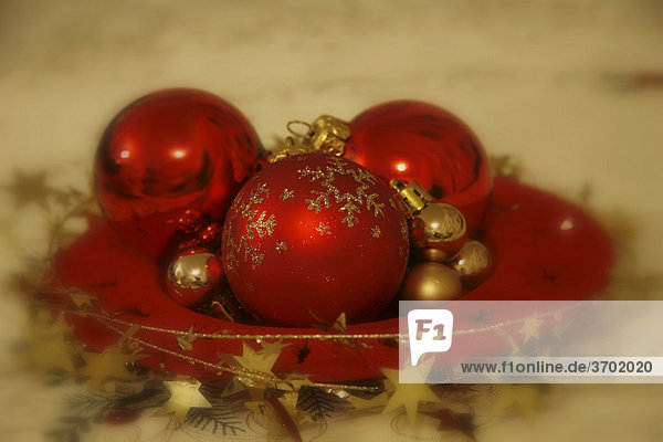 Rote Baumkugeln mit Girlanden auf Weihnachtsteller  Weihnachtsdekoration