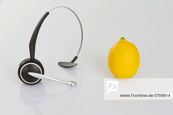 Headphone und Zitrone als Symbol für gesunde Ernährung am Arbeitsplatz