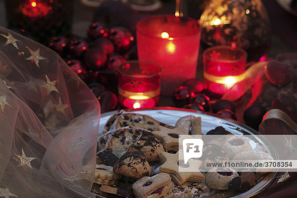 Stimmungsvolle  mit Lichtern arrangierte weihnachtliche Tischdekoration mit Weihnachtsgebäck