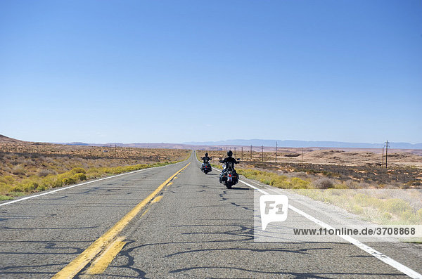 Two motorcyclists on a highway between Utah and Arizona  USA