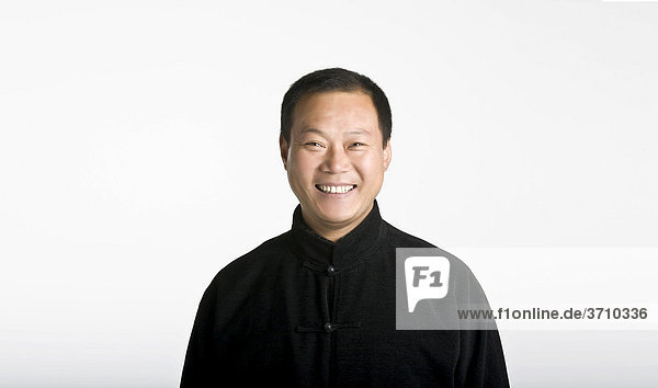 Portrait of the Chinese Taiji Master Cheng Lijun  laughing  wearing a traditional jacket