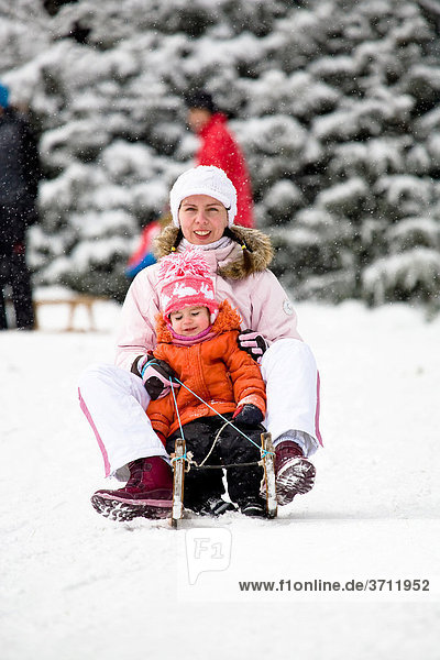 Sledding mother and daughter