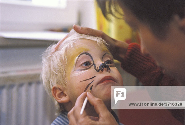Little boy is painted as a cat
