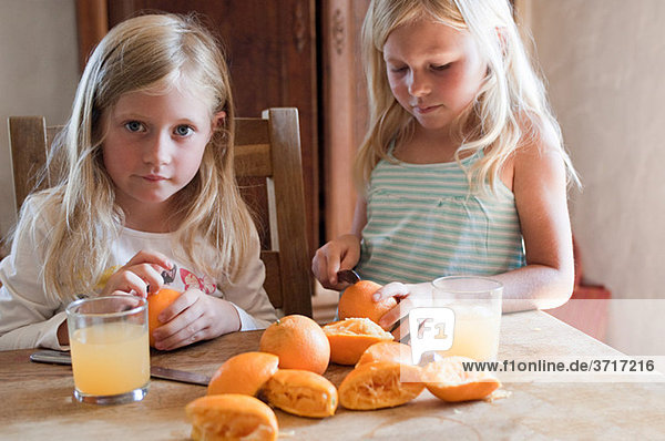 Mädchen machen frischen Orangensaft