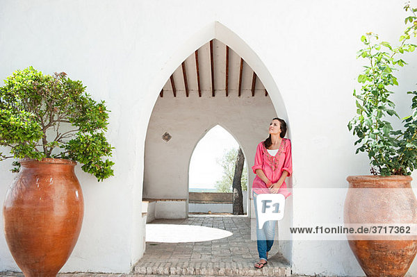Young woman standing by archway