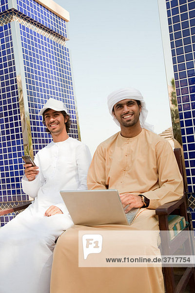 Zwei Männer aus dem Nahen Osten mit Laptop und Handy