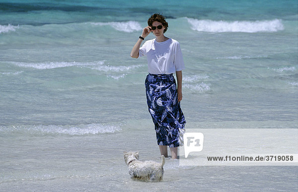 Junge Frau mit kleinem Hund an einem Strand auf Mallorca  Spanien