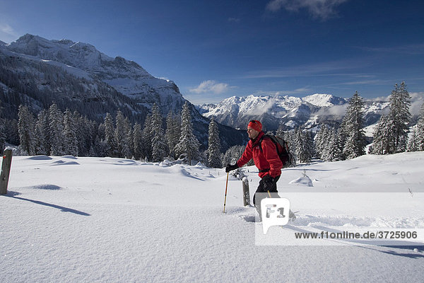 Snowshoe walker  Walenstoecken Mountains and Mt Widderfeldstock  in winter  Nidwalden  Switzerland