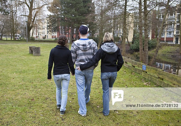 Three teenagers  back view  undecided youths taking a walk