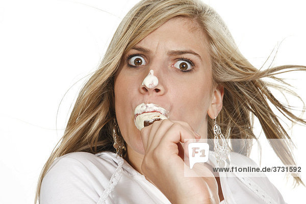 Junge Frau isst Eis am Stiel mit Eis verschmiertem Gesicht