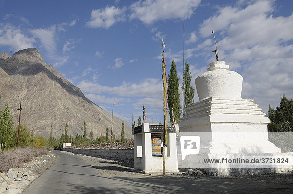 Buddhistische Chörten mit sehr langer Manimauer neben der Straße in der Oase Hundar  Nubratal  Ladakh  Jammu und Kashmir  Nordindien  Indien  Asien