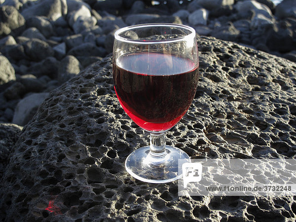 Weinglas mit Rotwein auf Lavastein  La Palma  Kanarische Inseln  Kanaren  Spanien