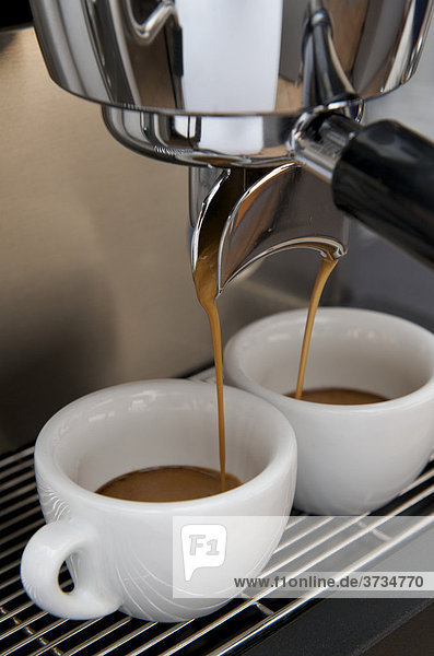 Professionelle Zubereitung von Espresso mit einer Siebträgermaschine: Der Espresso fließt aus dem Siebträger in die Espressotassen