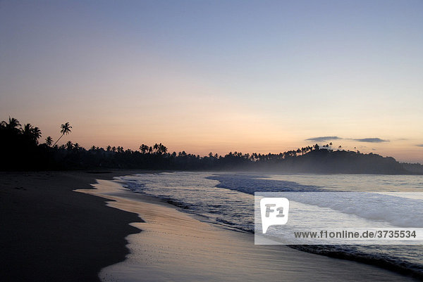Morgenrot am Meer  seichte Wellen am Sandstrand am frühen Morgen  Talalla bei Dondra  Indischer Ozean  Ceylon  Sri Lanka  Südasien  Asien