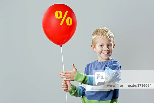 5-88year-old boy holding a balloon with the percent symbol