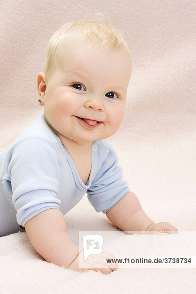 Lächelnder Säugling  Baby  7 Monate alt  streckt die Zunge raus