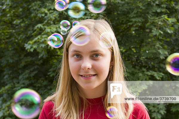 Dreizehnjähriges Mädchen inmitten von Seifenblasen