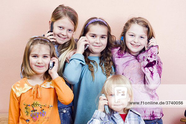 Gruppe von Kindern telefonieren  Mädchen (von links) 6  11  9 und 9 Jahre  Junge 4 Jahre alt