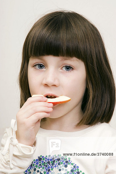 Little girl  6 years old  eating an apple