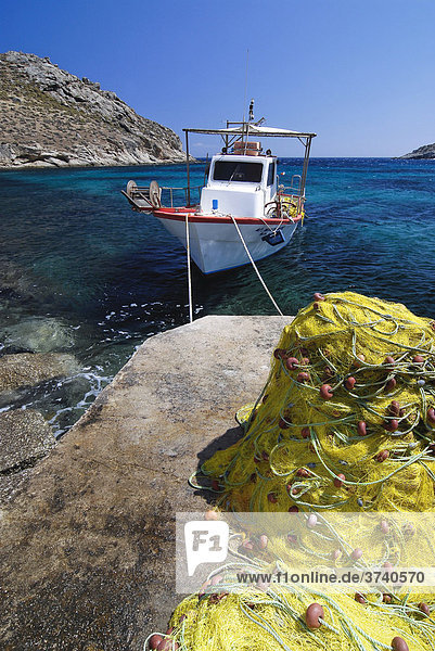Fischerboot im Meer  vorne ein gelbes Netz am Boden  Mykonos  Kykladen  Griechenland  Europa