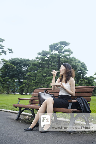 Young Asian woman in the park  sushi  lunch box  business  Tokyo  Japan  Asia