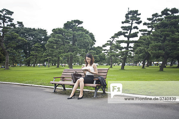 Young woman eating lunch in a park  Tokyo  Japan  Asia
