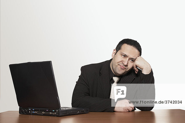 Businessman sitting in front of his laptop  bored