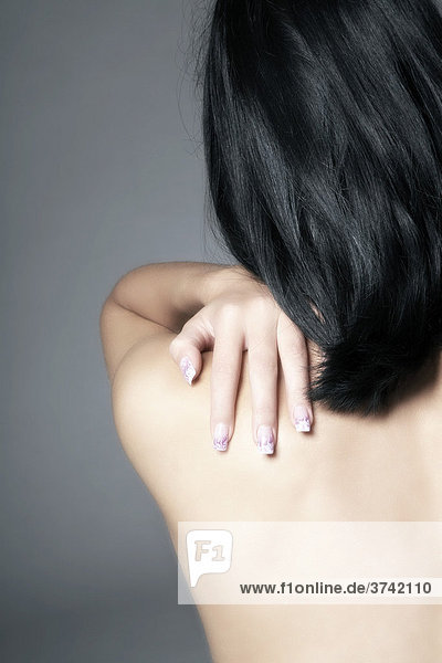 Dark haired young woman rubbing her shoulder  shoulder tension