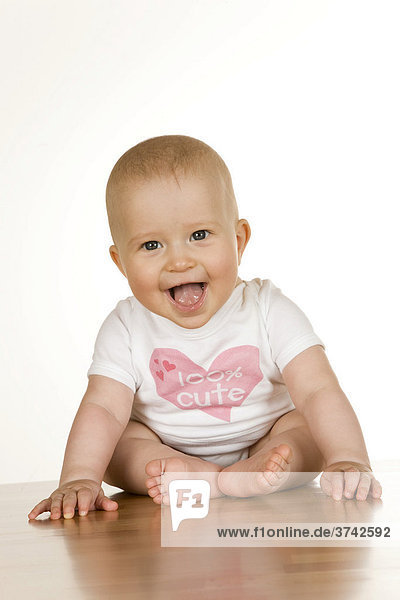 Baby  6 Monate  sitzt und lacht