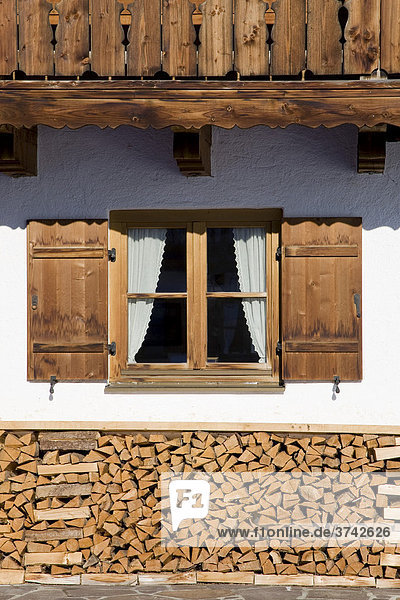 Fenster eines Bauernhauses mit Holzstapel  Bayern  Deutschland  Europa