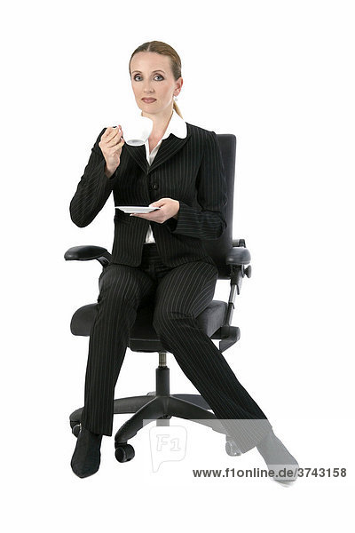 Woman sitting on an office chair  drinking coffee
