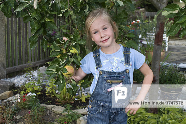 Mädchen  5 Jahre  steht unter einem kleinen Apfelbaum