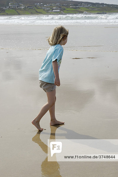 Blondes Mädchen  5 Jahre  läuft barfuß über von Ebbe freigelegten feuchten Sandstrand  Donegal  Irland  Europa