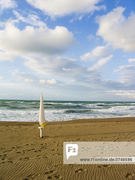Ein geschlossener Sonnenschirm an einem verlassenem Strand in Marina di Lesina  Foggia  Apulien  Italien  Europa