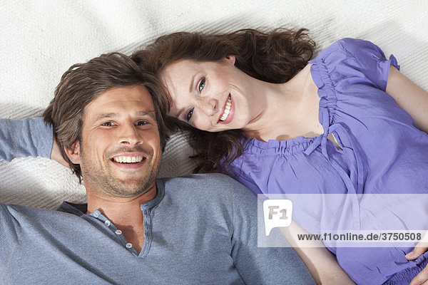 Glückliches Paar auf einem Teppich liegend
