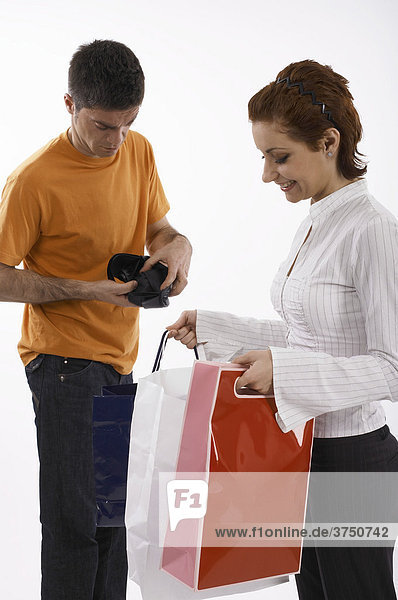 Woman with full shopping bags  man with empty wallet