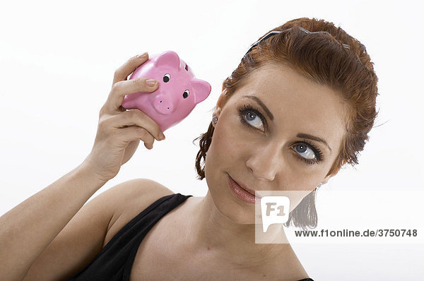 Woman listening to a piggy bank