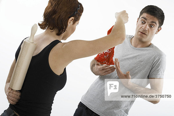 Woman holding a pair of red panties accusingly in front of a man