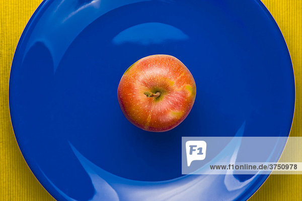 Apfel auf blauem Teller