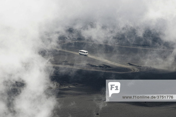 Bus driving along a road  smoke and fog  Mt. Etna  Sicily  Italy