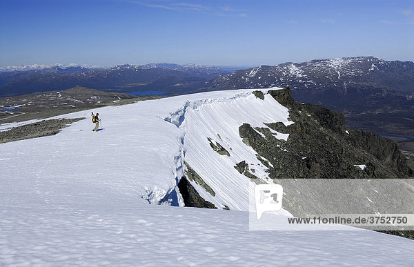 Hiker  snow cornices  vast snowy landscape  Jotunheinem National Park  Norway  Scandinavia