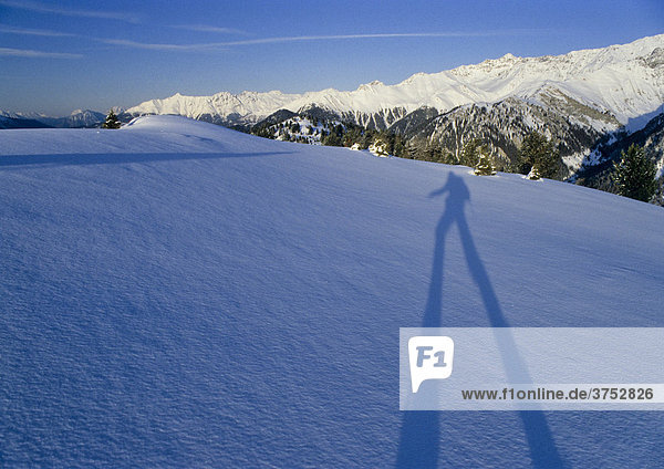 Langer Schatten eines Skitourengehers fällt auf ein Schneefeld  hinten Gipfel der Ötztaler Alpen  Tirol  Österreich  Europa