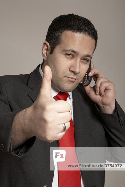 Businessman gesturing positive telephone conversation  thumbs-up