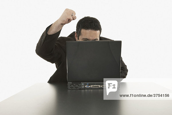 Geschäftsmann sitzt wütend hinter seinem Laptop