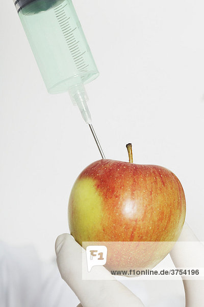 Chemiker spritzt Substanz in Apfel